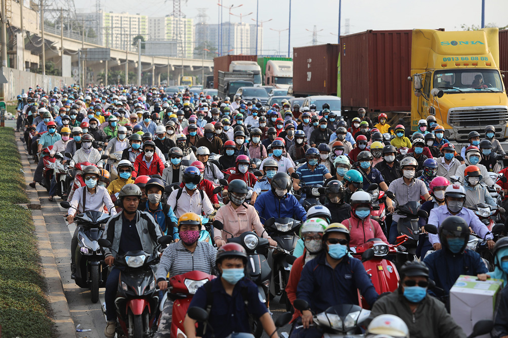 Xe đầu kéo, ôtô các loại xếp hàng mua vé qua trạm, người điều khiển xe máy bị chôn chân, nhích từng chút một ngay bên trạm thu phí.