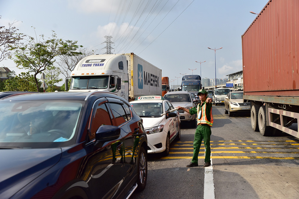 Lực lượng CSGT và thanh niên xung phong phải phân làn trước trạm ở cả hai hướng để điều tiết các loại xe vào đúng làn.