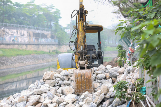 Máy xúc được huy động để ép cọc chống sạt lở, sau đó nhà thầu sẽ tiếp tục chôn ống thu gom nước thải và thi công trải bê tông, làm hố ga.