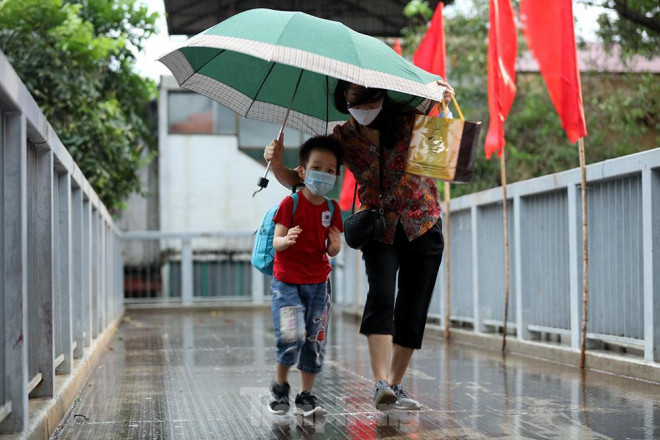 Bà đưa cháu đi trên cầu thang bộ qua đường để đến lớp học