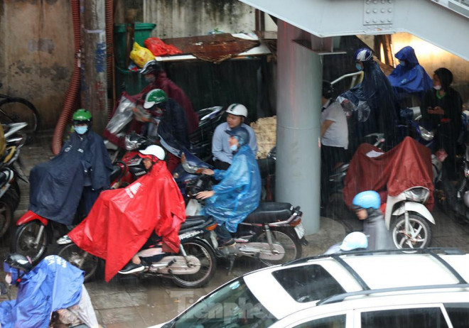 Đường tắc cộng với mưa to nên nhiều người dân tranh thủ trú mưa dưới gầm cầu thang đi bộ