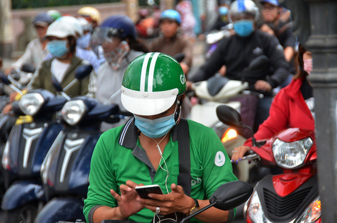 Dễ dàng bắt gặp hình ảnh những tài xế công nghệ xanh, vàng trên đường phố TP.HCM hay Hà Nội. (Ảnh: NLĐ)