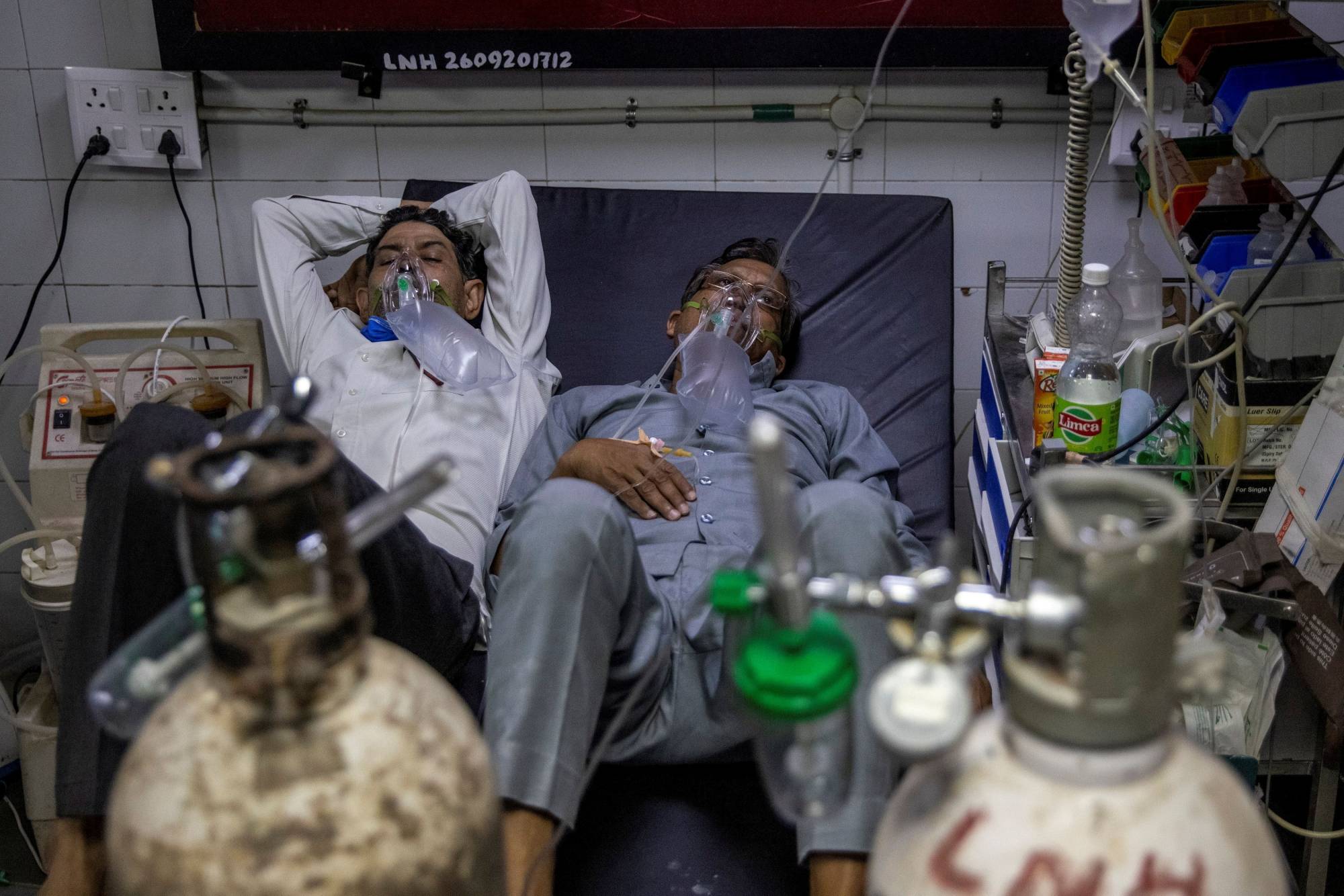 Cảnh hai bệnh nhân chia sẻ một giường bệnh ở Ấn Độ.