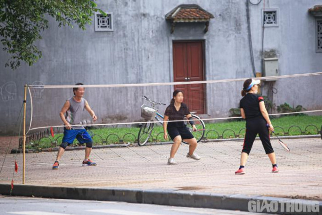 Nhóm người chơi cầu lông nhưng không đeo khẩu trang, một số đeo khẩu trang nhưng kéo xuống khỏi miệng.