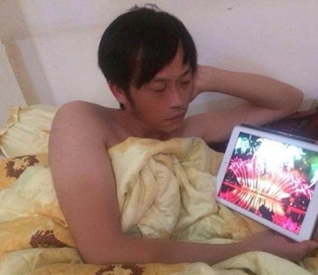 Hoài Linh khoe ảnh cởi trần nằm trên giường xem clip giải trí trên máy tính bảng.
