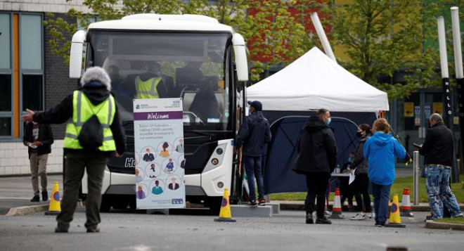 Người dân xếp hàng bên ngoài trạm tiêm chủng di động ở thị trấn Bolton - Anh hôm 13-5 Ảnh: REUTERS