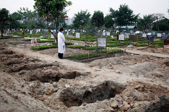 Người đàn ông đứng trước mộ người thân qua đời vì Covid-19 ở&nbsp;Dhaka, Bangladesh.