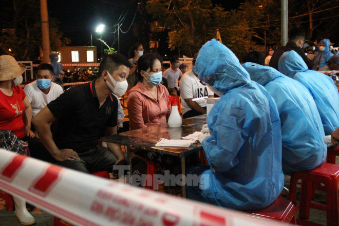 Tại bàn khai báo, các tiểu thương, ngư dân cung cấp thông tin gồm họ và tên, năm sinh, địa chỉ, số điện thoại để nhân viên y tế ghi lại. Ảnh: Giang Thanh