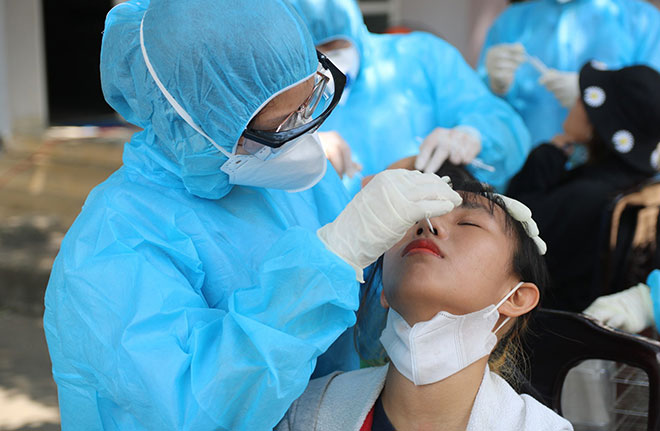 Nhân viên y tế lấy mẫu xét nghiệm virus SARS-CoV-2. Ảnh: Hồng Lam