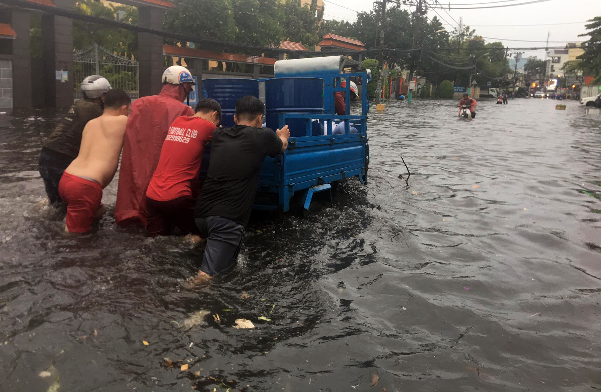 Trong lúc tài xế đang không biết xử lý thế nào để đưa phương tiện bị chết máy thoát khỏi khu vực ngập nước thì nhiều người dân tốt bụng đã xúm vào hỗ trợ, đẩy xe giúp.