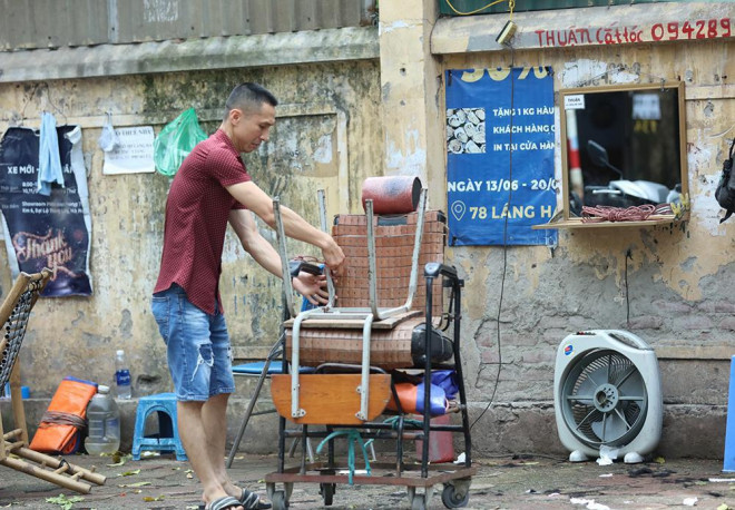 Quán cắt tóc vỉa hè thu dọn đồ nghề trong buổi sáng 25/5