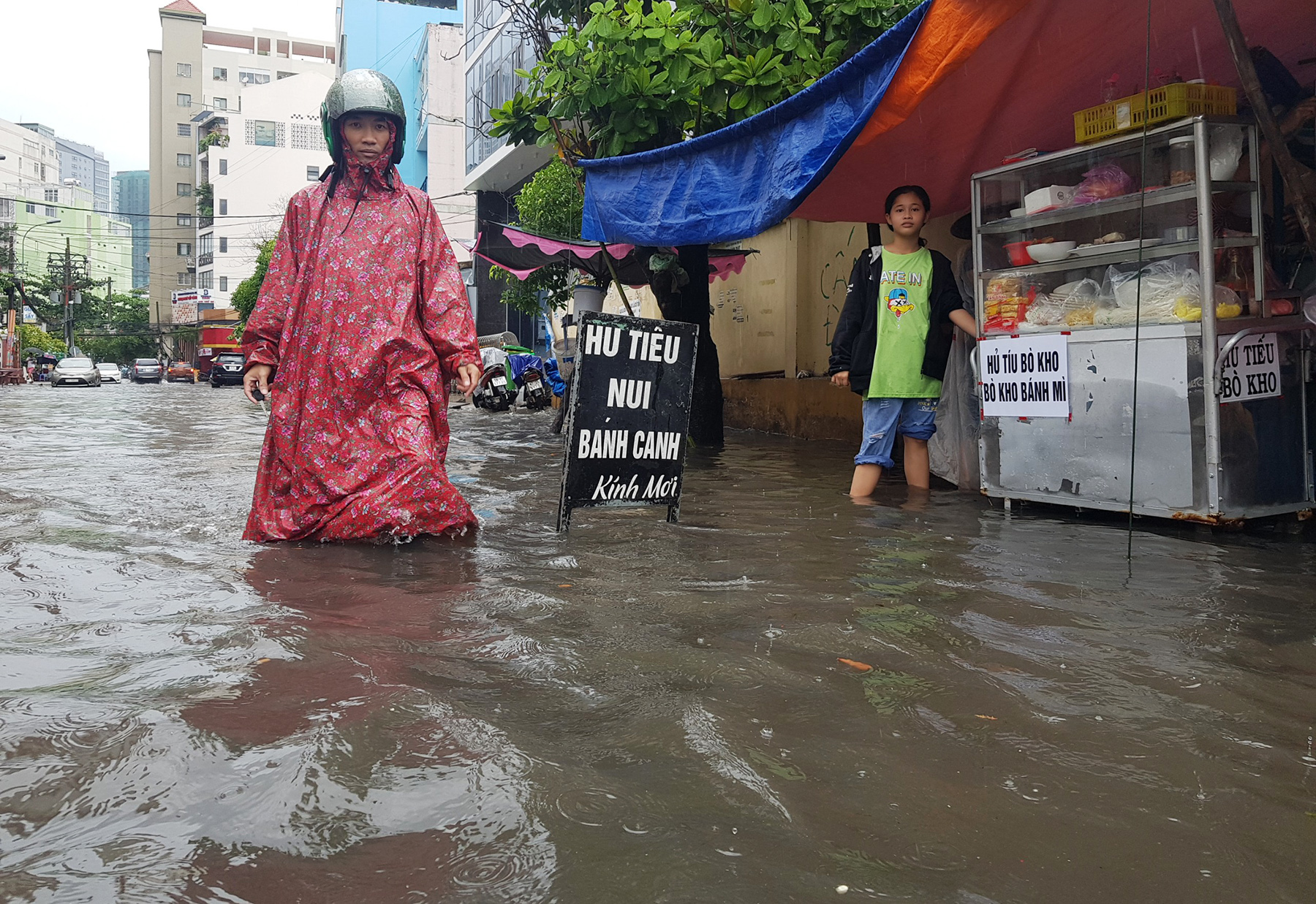 Người đi bộ bì bõm lội nước ngập đến đầu gối. Một số người buôn bán hai bên đường bị ngưng trệ. Đến 11h trưa, khu vực quận Bình Thạnh vẫn đang xảy ra mưa lớn.