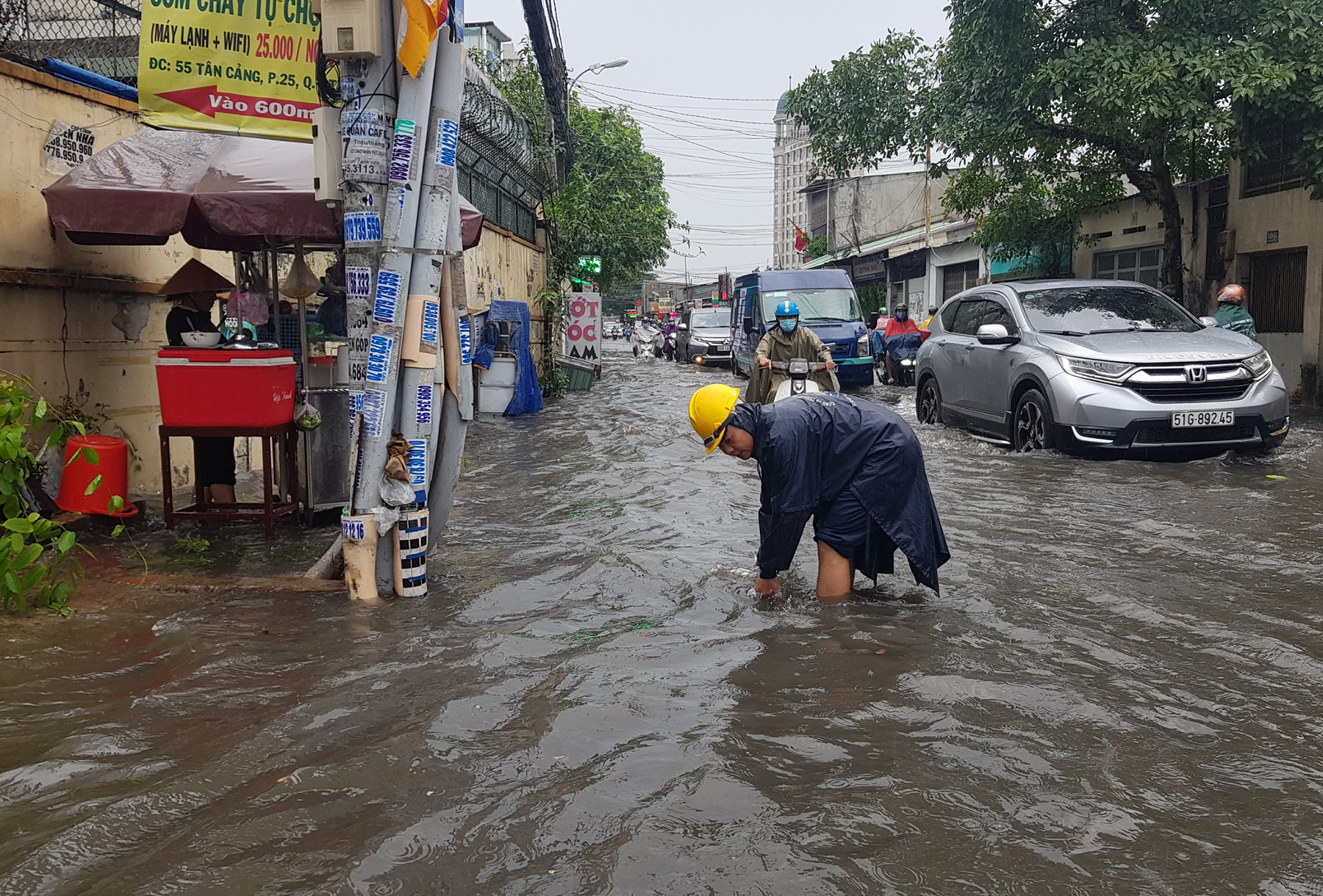 Công nhân công ty thoát nước đô thị túc trực khơi thông các cống trên đường để nước thoát nhanh hơn.