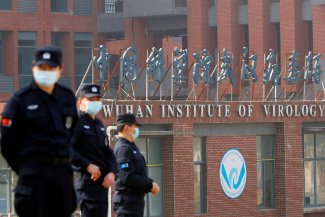 Nhân viên an ninh đứng canh ngoài Viện Virus học Vũ Hán khi nhóm điều tra WHO tới đây ngày 3-2. Ảnh: The Japan Times