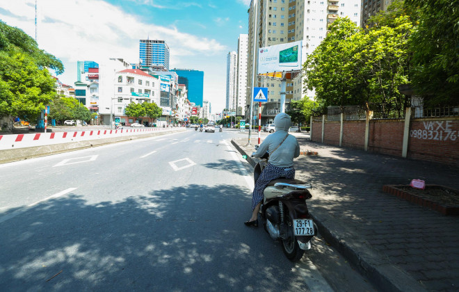 Nhiều người dân di chuyển trên đường tìm bóng mát khi chờ đèn đỏ