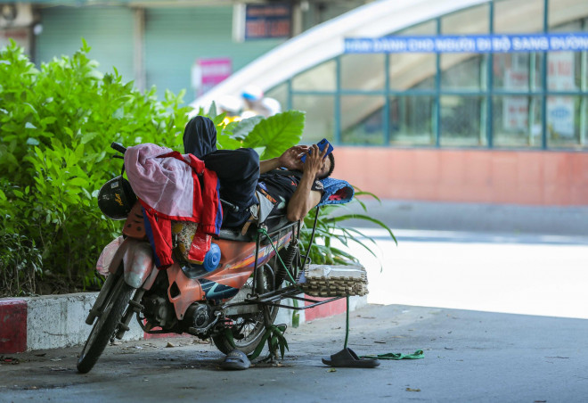 Một số người giao hàng tìm khu vực gầm cầu có bóng mát để nghỉ ngơi