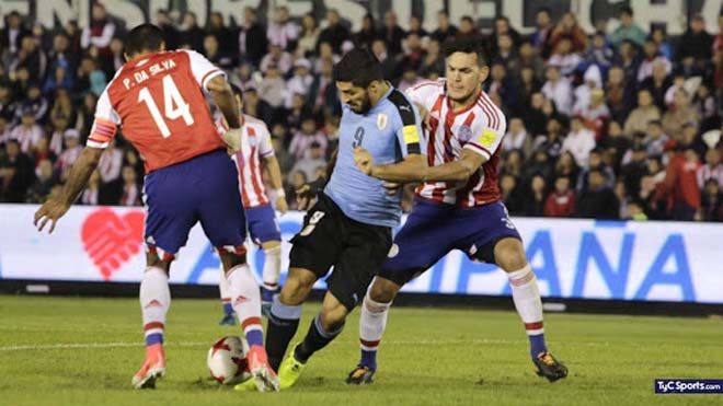 Suarez (áo xanh) bất lực trước hàng phòng ngự Paraguay