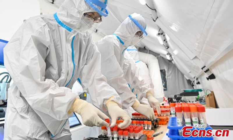 Các nhân viên y tế kiểm tra các mẫu xét nghiệm axit nucleic trong phòng xét nghiệm Covid-19 di động ở nhà thi đấu Quảng Châu, tỉnh Quảng Đông, Trung Quốc hôm 3/6. Ảnh: China News Service