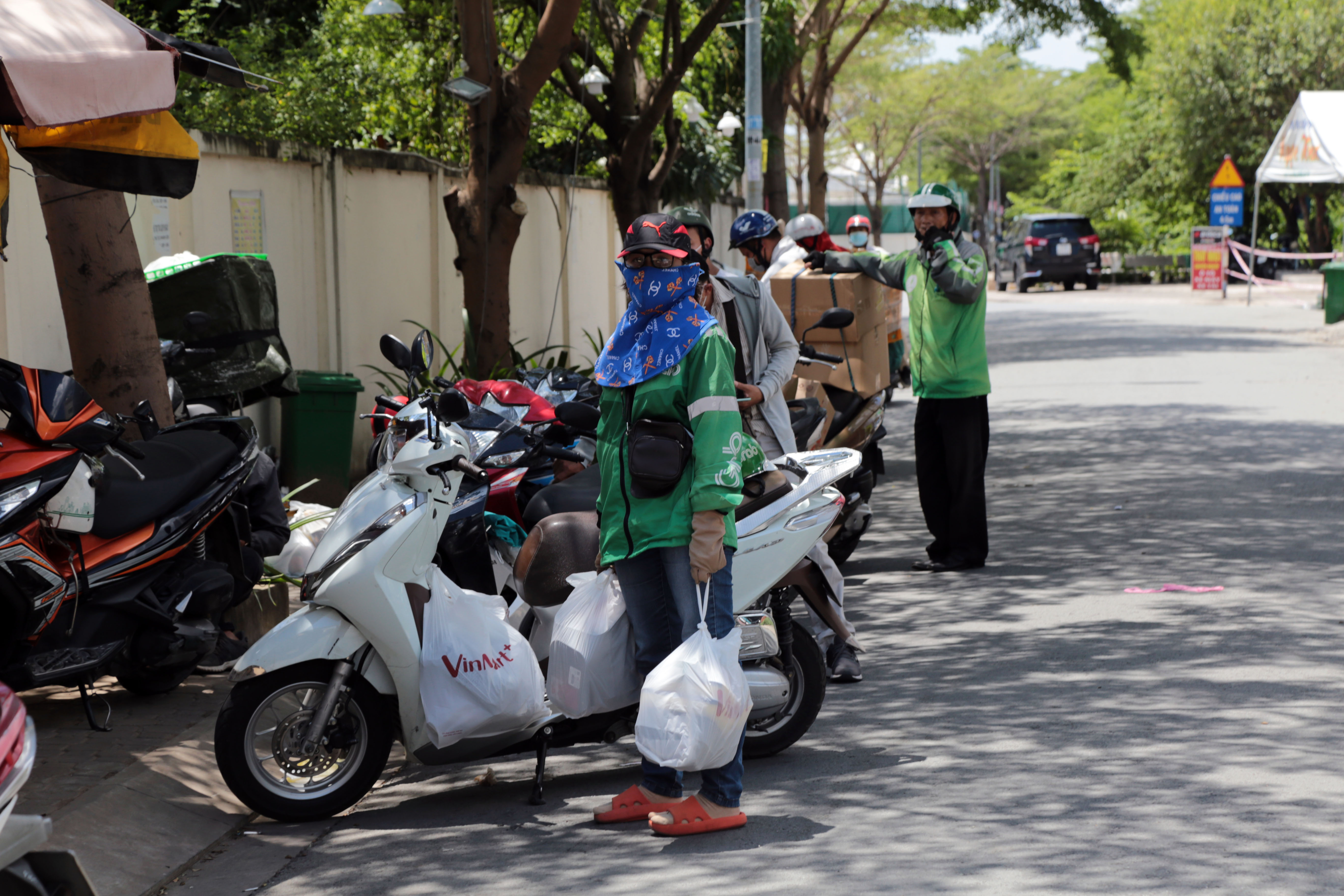 Không thể vào bên trong, nhiều shipper xếp thành hàng dài trước chốt phong tỏa chung cư Ehome 3 để giao cho lực lượng tại chốt, gửi giúp cho cư dân.