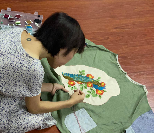 Chị Hà Mai đang tận dụng những mảnh vải vụn để thiết kế thành áo.