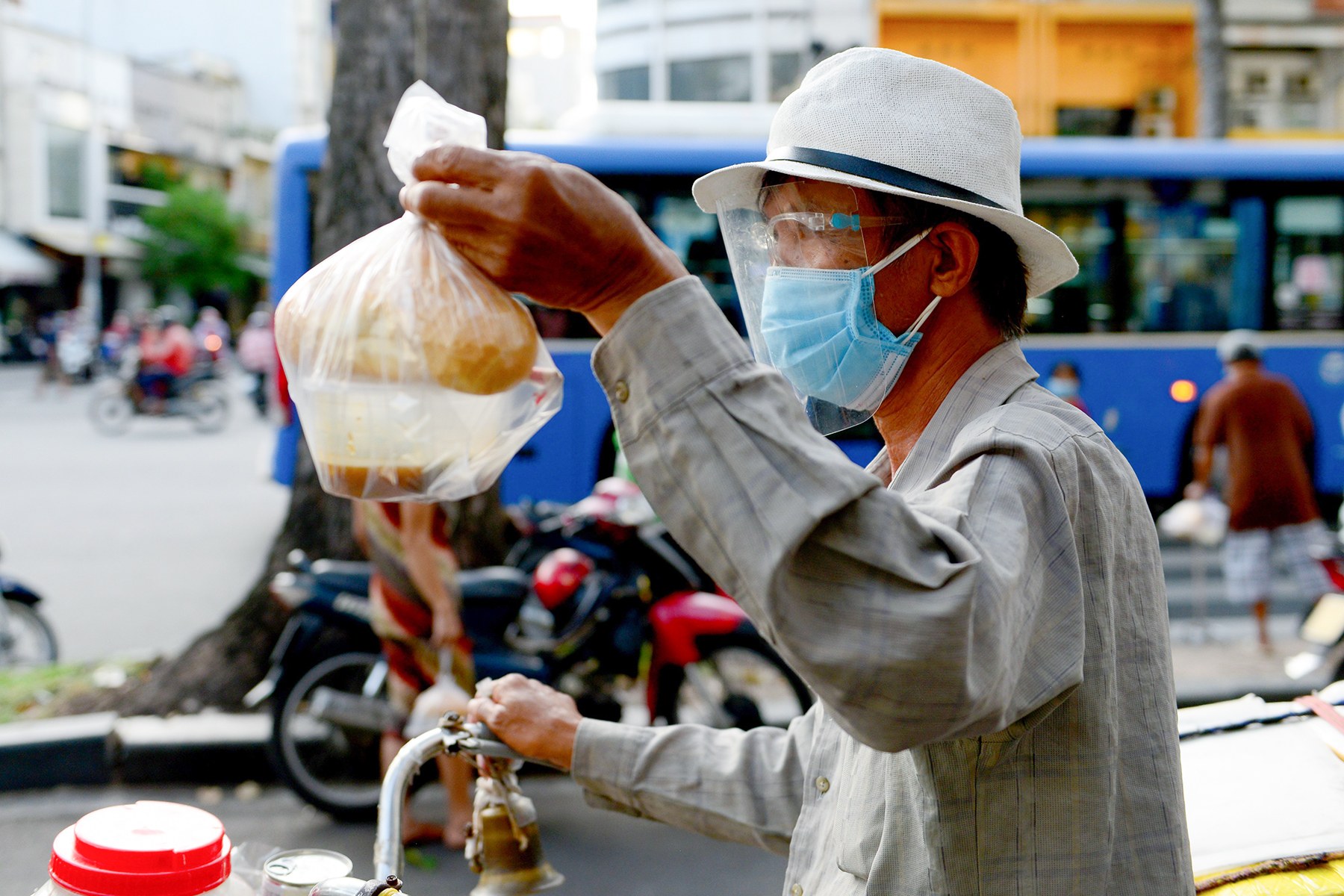 Nhận suất ăn còn nóng hổi, người thì mang đi, người tìm chỗ ngồi ăn.