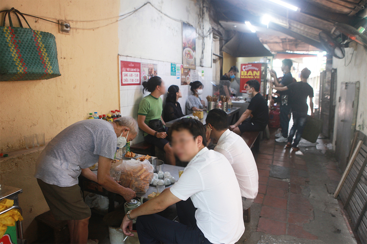 Bên trong quán dù có vách ngăn nhưng lượng khách đến quá đông nên phải ngồi sát nhau đợi nhân viên mang phở đến. Bên cạnh quán phở là một quán trà đá, người dân đến ngồi uống trà mà không đeo khẩu trang.