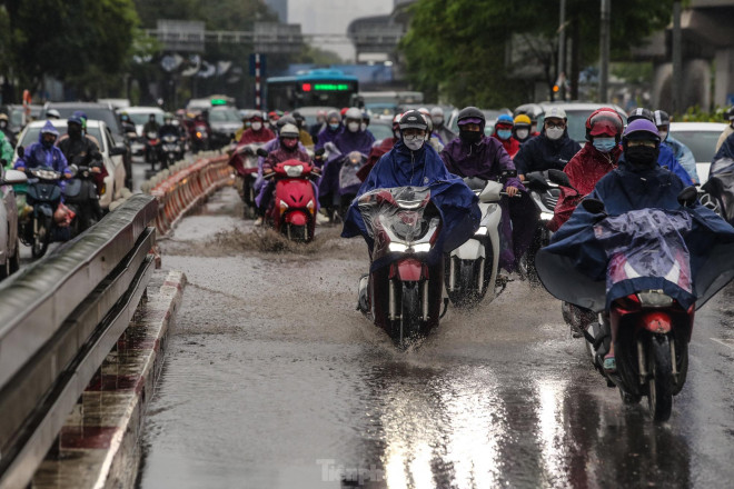 Vũng nước trên cầu vượt Ngã Tư sở khiến các phương tiện di chuyển khó khăn.