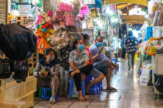 Một nhóm tiểu thương tại chợ ngồi trò chuyện chờ khách