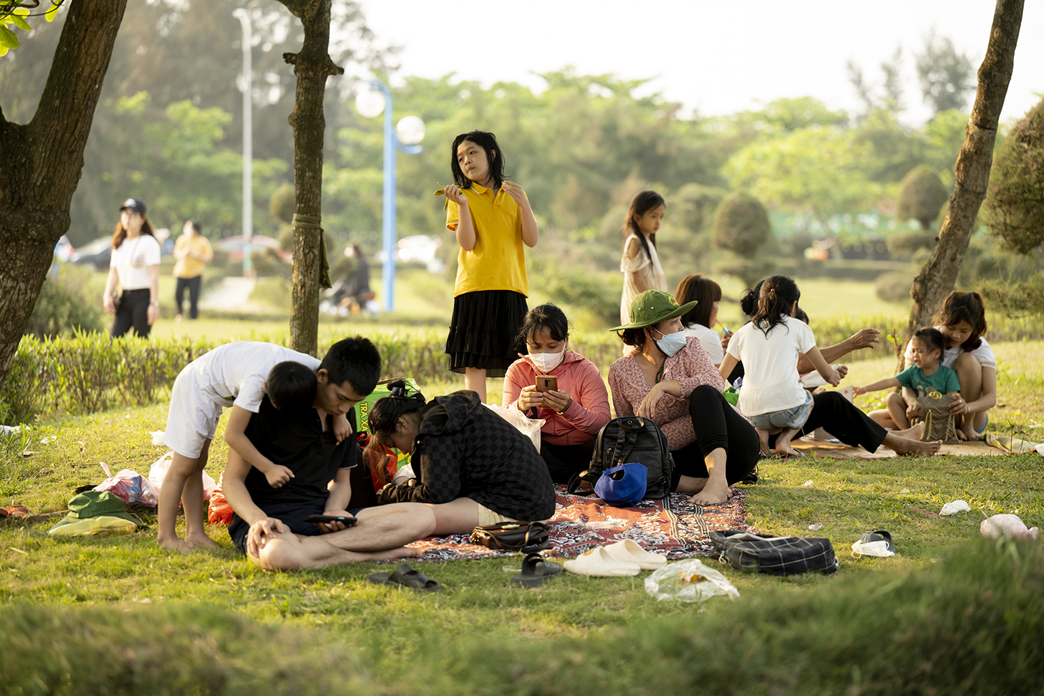 Một gia đình từ Hà Tĩnh ra đã tận dụng bãi cỏ công viên để làm chỗ nghỉ ngơi để đợi tới giờ xuống tắm biển.