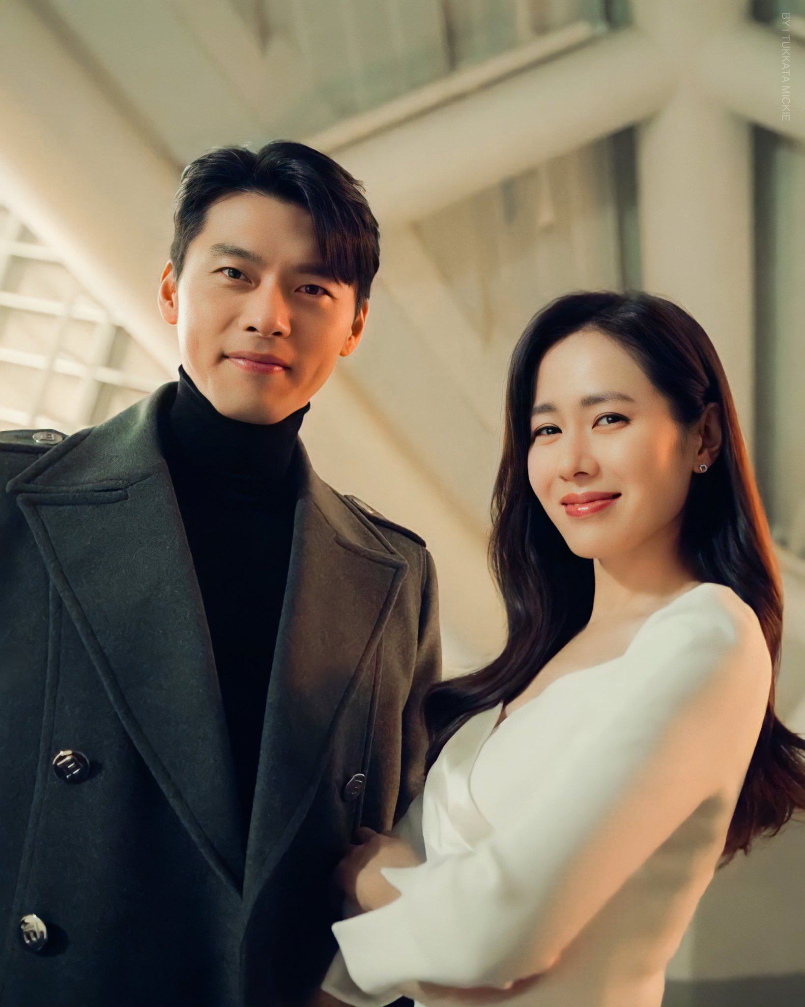 Ở đây, Hyun Bin chọn diện áo cổ lọ kết hợp áo khoác dạ. Trong khi đó, Son Ye Jin thì diện thiết kế váy trắng dài tay với kiểu cổ vắt chéo.