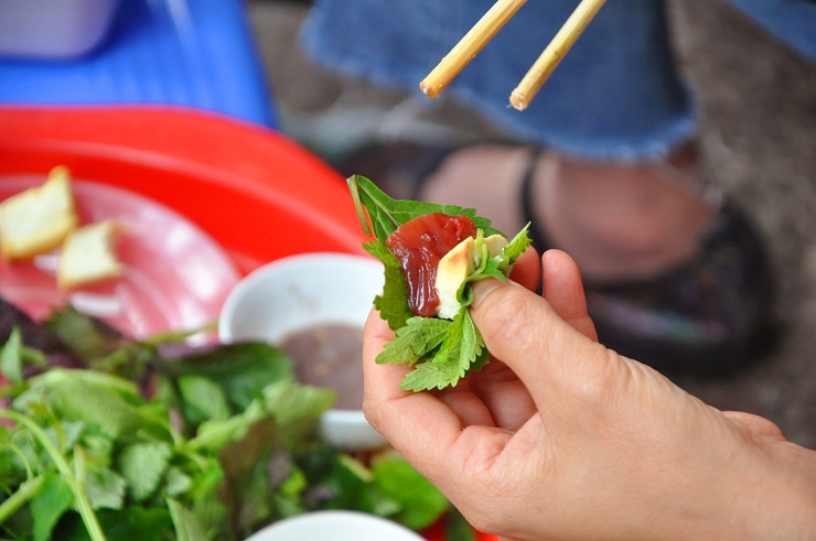 Cầm miếng chanh tươi vắt vào bát mắm tôm, thêm lát ớt rồi đánh cho sủi bọt, nhẹ nhàng cuộn miếng sứa chấm và thưởng thức, chị Thảo cho biết, năm nào chị cũng đi 15km từ Mỹ Đình lên phố cổ để ăn sứa đỏ.