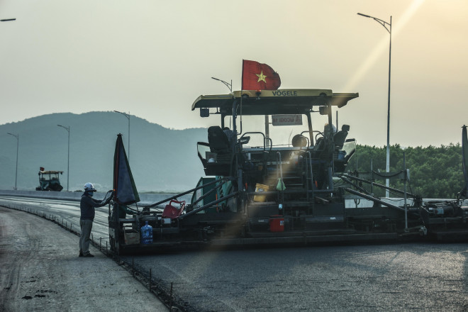 Đơn vị thi công thảm lớp bê tông nhựa cuối cùng mặt đường dẫn lên cầu Vân Tiên.