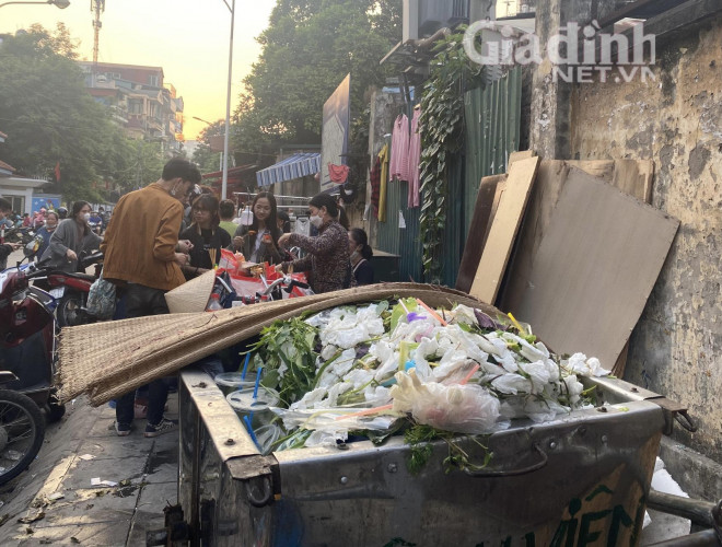 Trước cổng trường Tiểu học Đặng Trần Côn có khoảng 5-6 chiếc xe rong chứa đầy thịt chiên/nướng, xúc xích...Dù đứng cạnh thùng chứa đầy rác, nhếch nhác, mùi nồng nặc nhưng vẫn...hút khách.