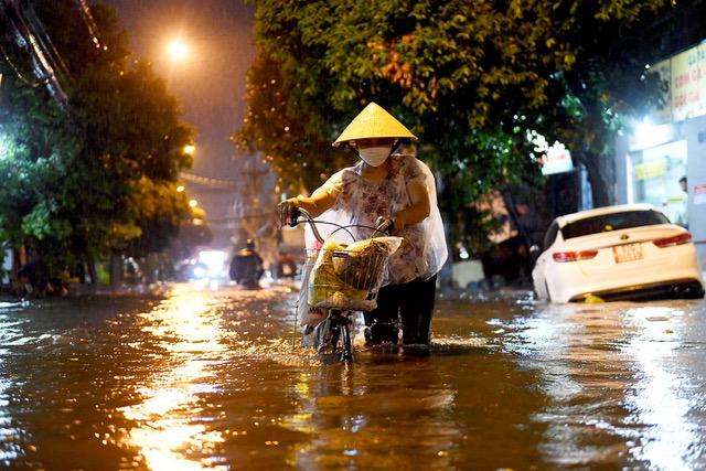 Nhiều người phải vật lộn với dòng nước trên các tuyến đường để về nhà trong cơn mưa lớn.