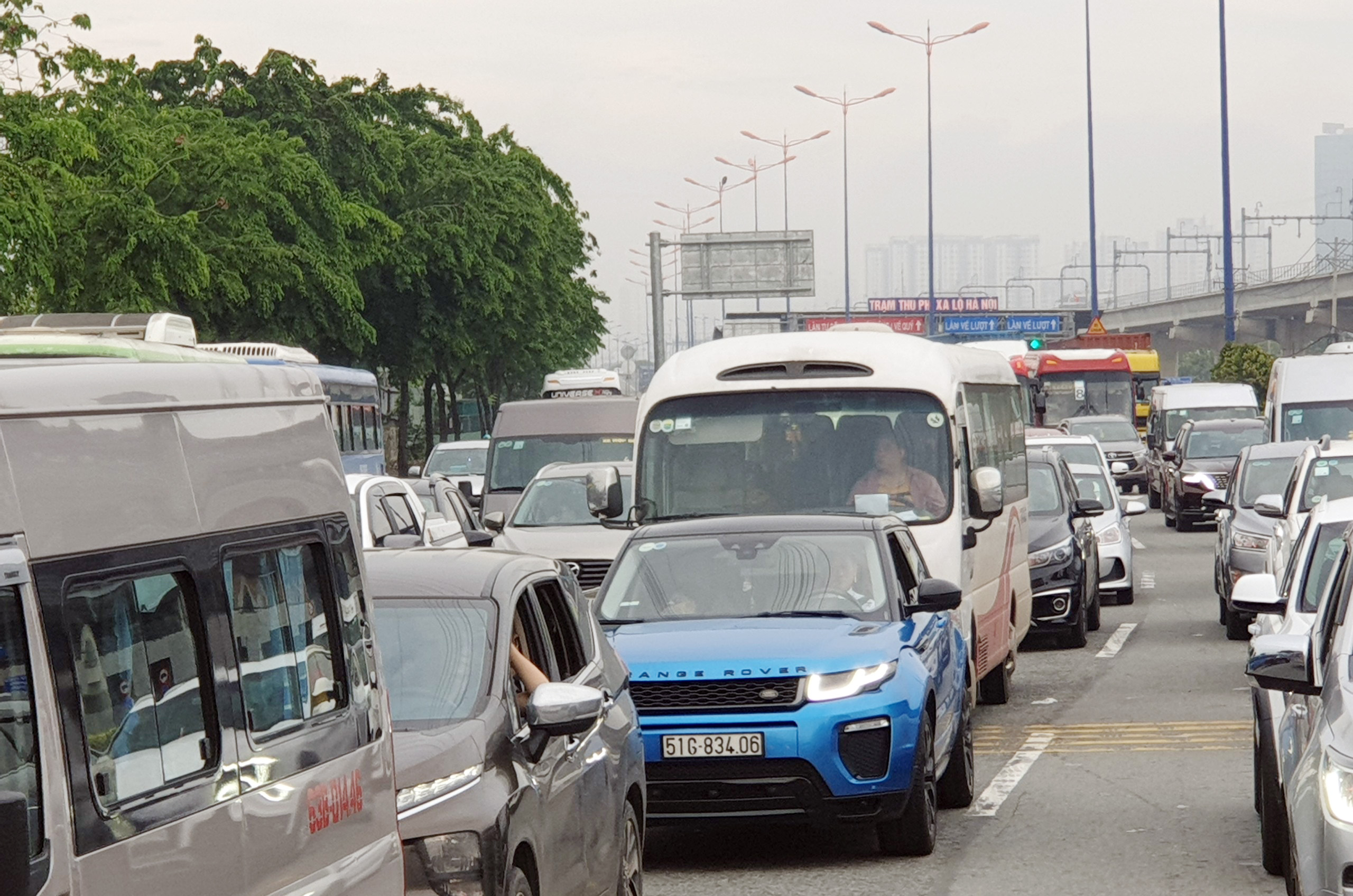 Sáng sớm nay, trên xa lộ Hà Nội đoạn trước trạm thu phí BOT xa lộ Hà Nội, ô tô xếp hàng dài cả trăm mét để chờ mua vé qua trạm. Để qua khu vực này, mỗi ô tô phải mất 15 phút.