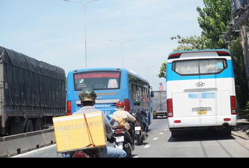 Làn đường cho xe máy bị thu hẹp vì ôtô trên Quốc lộ 1, đoạn qua quận 12, TP HCM Ảnh: Tuyết Trinh