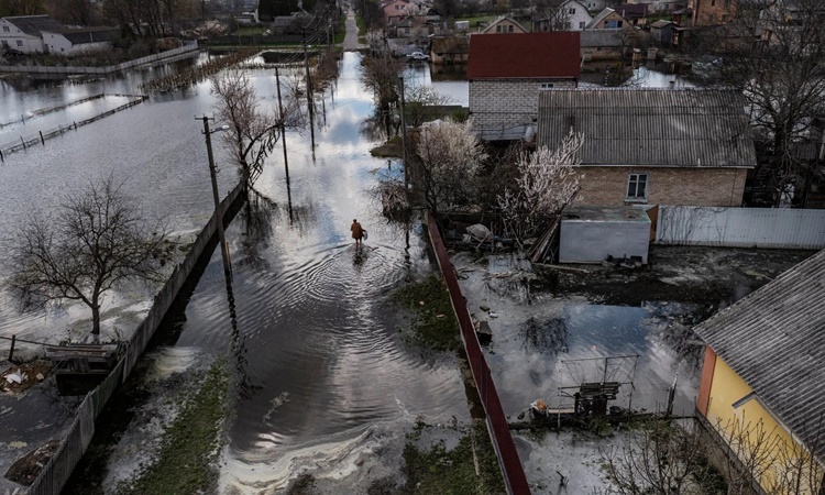 Dân làng Demydiv&nbsp;đi trên con đường ngập nước (ảnh: NY Times)