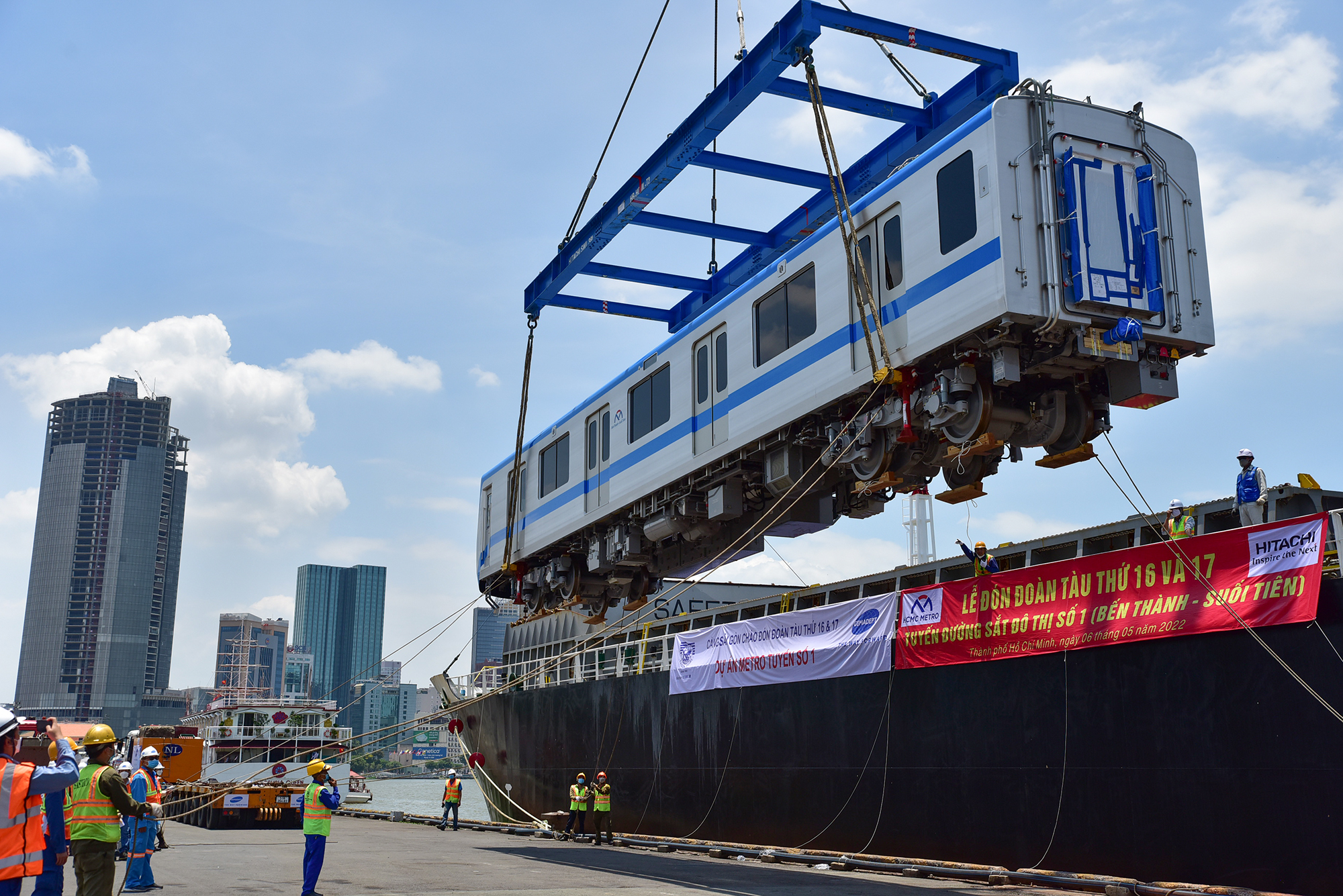 Dây kéo tàu ở 4 góc được các công nhân điều chỉnh phối hợp nhịp nhàng theo hiệu lệnh của những người điều khiển và người lái cẩu tàu đặt chính xác vào vị trí xe siêu trường siêu trọng đậu sẵn.