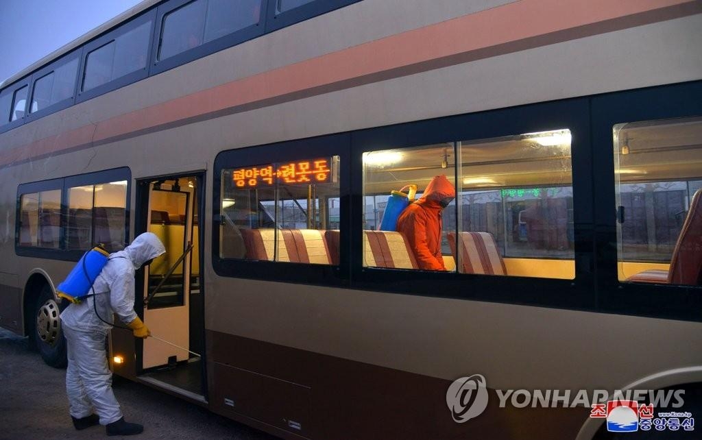 Nhân viên y tế Triều Tiên khử trùng một chiếc xe bus ở Bình Nhưỡng (ảnh: KCNA)