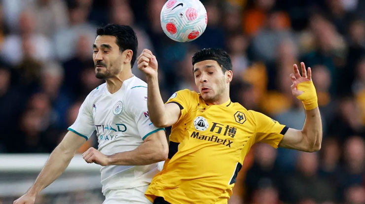 Ilkay Gundogan nhảy lên tranh bóng với Raul Jimenez