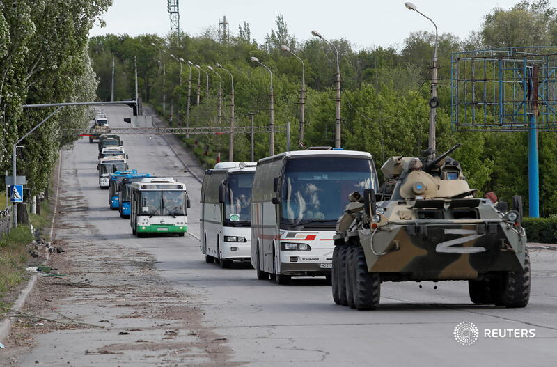 Xe quân sự hộ tống các xe buýt chở binh sĩ Ukraine rời nhà máy&nbsp;Azovstal hôm 17/5. Ảnh: Reuters