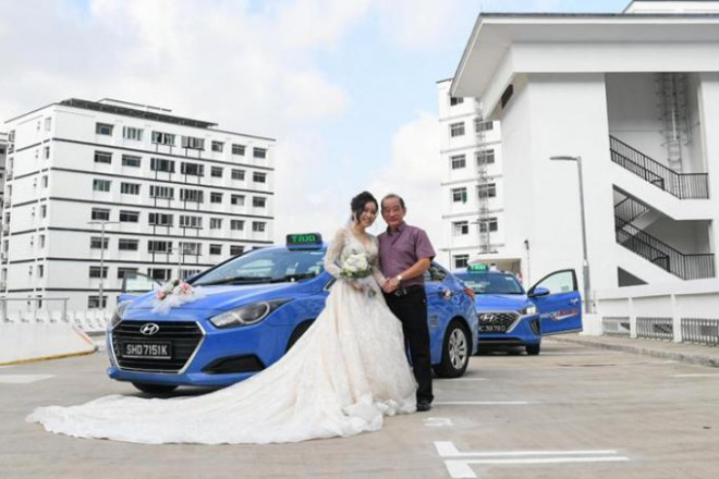 Cô dâu chụp ảnh cùng bố ruột bên chiếc taxi dùng làm xe rước dâu. Ảnh: Straits Times