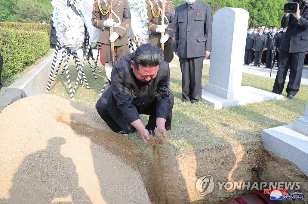 Ông Kim Jong Un thả&nbsp;đất xuống&nbsp;mộ của Nguyên soái Hyon Chol Hae.