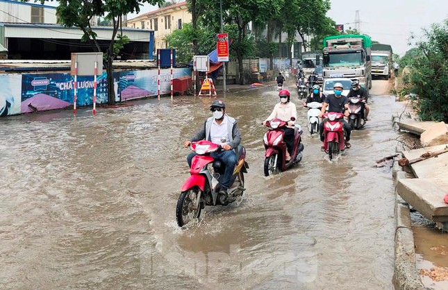 Nước vẫn ngập toàn bộ lòng đường, và vỉa hè nên để đi qua được đường gom Đại lộ Thăng Long đoạn khu đô thị Nam An Khánh, Thiên đường Bảo Sơn người điều khiển xe máy, ô tô đều phải chấp nhận cho xe "bơi" qua.