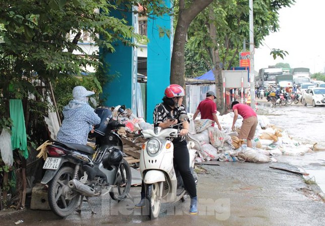 Do ngập sâu, nhiều chủ phương tiện xe máy là nữ điều khiển đã không dám "phiêu lưu" đi qua khu vực ngập, đành đứng bên vệ đường để tìm hướng di chuyển mới.