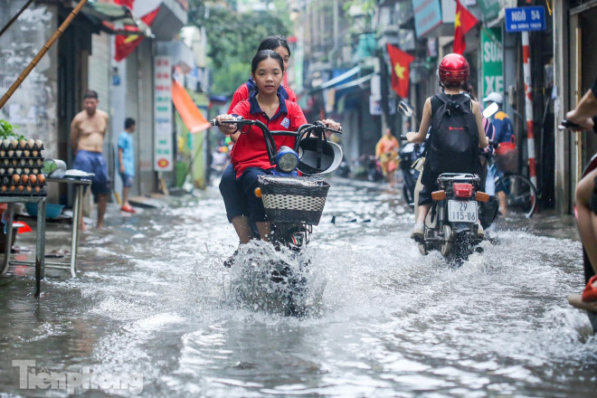 Khu vực này ngập sâu khoảng 20-30cm khiến những người tham gia giao thông di chuyển khó khăn.