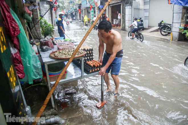 Người dân buôn bán tại khu vực phố trên đều phải kê bàn cao hơn tránh nước mưa.