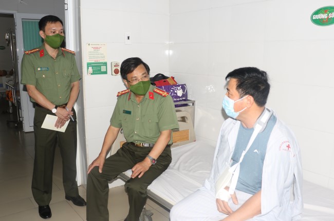 Đại tá Hồ Văn Tứ thăm hỏi trung tá Nguyễn Sỹ Hải - Ảnh: Công an cung cấp
