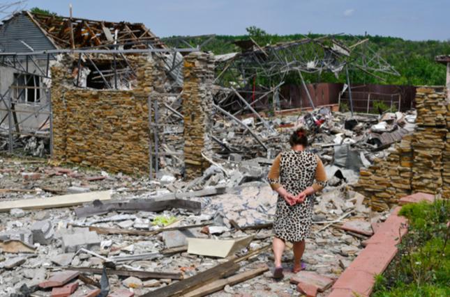 Một phụ nữ đi trong khu nhà đổ nát ở Sloviansk ngày 1/6. (Ảnh: AP)