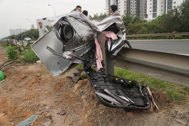 Một phần của chiếc xe Toyota Fortuner còn bám lại trên hộ lan tôn sóng.